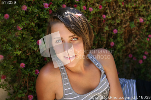 Image of Beautiful teenage girl on background flowers