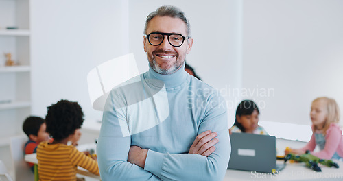 Image of Portrait, man and teacher with arms crossed, classroom and education with children, students and employee. Face, happy person and educator with kids, learning and teaching in a school and knowledge