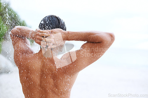 Image of Shower, beach and man with water for cleaning, washing hair and grooming for healthy skin. Beauty, nature and back of person with splash for hygiene, wellness and skincare hydration and cleanse