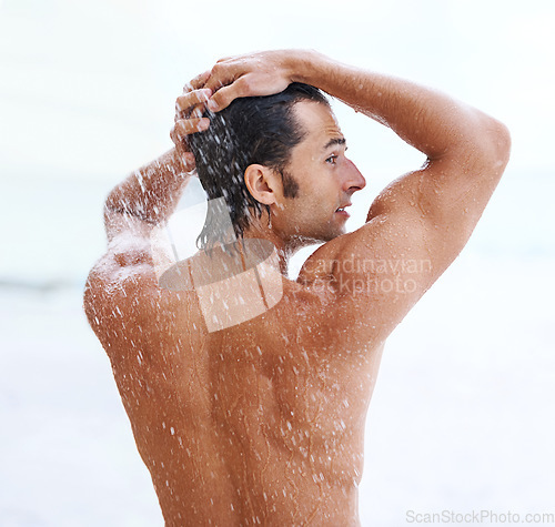 Image of Shower, beach and man with water for cleaning, washing and grooming for healthy skin. Nature, treatment and back of person with splash for natural hygiene, wellness and skincare hydration outdoors