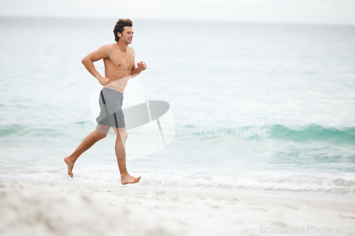 Image of Man, music and running on beach training workout, cardio playlist or summer sport exercise. Male person, streaming listening and fitness at sea or headphones speed performance, healthy body or audio