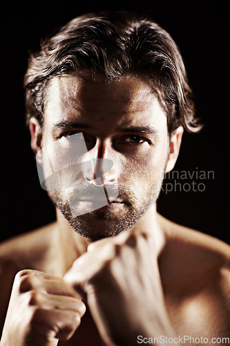 Image of Portrait, man and fist of serious boxer in studio isolated on a black background. Face, boxing and confidence of topless athlete ready for fight, exercise training or workout, sport or combat fitness