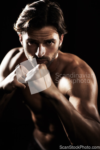 Image of Portrait, body of man and fist of boxer in studio isolated on black background. Serious face, boxing or muscle of topless athlete ready to fight, exercise or training, combat sport or fitness workout