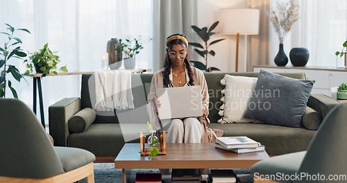 Image of Freelance, laptop and Indian woman on sofa for social media, research or streaming at home. Tech, remote work or lady entrepreneur online in living room for email, learning or upskill training course