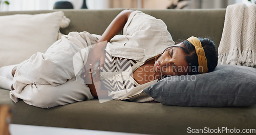 Image of Stress, anxiety and woman with stomach pain on sofa for gas, constipation or pms crisis at home. Menstruation, tummy ache or lady person with gut health problem, virus or endometriosis in living room
