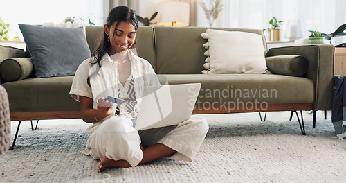 Image of Woman, laptop and credit card for home online shopping, fintech payment and e commerce on living room floor. Young person typing on computer for internet banking, web subscription or loan on carpet