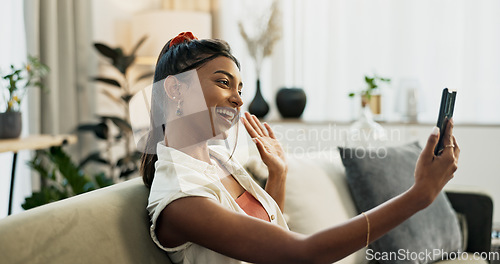 Image of Phone, happy or Indian woman on a video call on a sofa or couch to relax in living room or apartment. Wave, communication or excited person on mobile conversation with smile in lounge of modern home