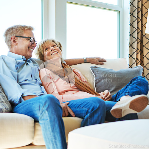 Image of Laughing, mature or happy couple in home to relax, enjoy conversation or joke together in retirement. Care, funny woman or senior man talking with love, support or smile on house living room couch