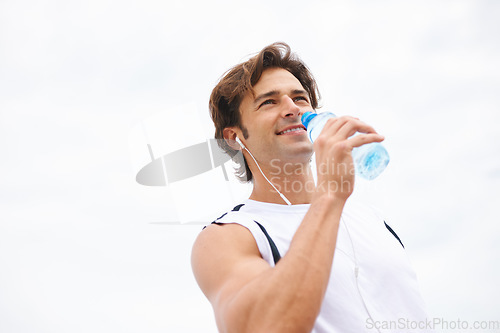 Image of Man, smile and drinking water on break from workout, earphones and hearing music, podcast or song on run. Male athlete, thirsty and hydrated for exercise, cardio and fitness outdoor with mockup