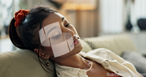 Image of Depression, sad and young woman on sofa relaxing with an idea or memory in living room. Burnout, mental health and nervous Indian female person with stress chilling in the lounge of modern apartment.