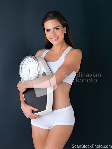 Image of Happy woman, portrait and scale to lose weight, diet or fitness for health and wellness against a studio background. Female person or model smile with weighing machine in healthy body on mockup space