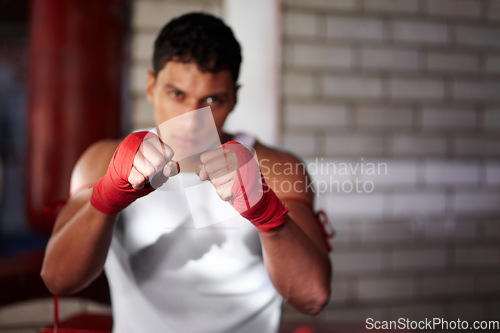 Image of Fist, portrait and a man at the gym for boxing, fitness or training for a competition. Sports, club and a fighter, boxer or person getting ready for a fight, cardio or a martial arts champion