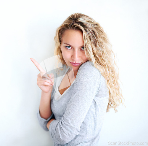 Image of Woman, portrait and pointing finger playful or flirt fun, white wall background as mockup space. Female person, confident and goofy face emoji hand gesture or showing attention, joke humor in Canada