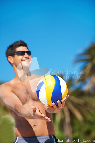 Image of Volleyball, sports and happy fitness man at a beach with ball serve, energy or freedom on blue sky background. Smile, sports or male player with handball in nature for workout, game or performance