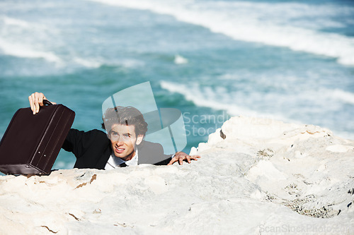 Image of Climbing, outdoor cliff or businessman with stress for job, career opportunity or work in a beach. Professional, briefcase or tired corporate worker hanging on edge with anxiety, depression or danger