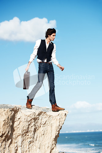 Image of Businessman, thinking and standing on a cliff by the beach for adrenaline, adventure or a break in nature. Idea, walking and a worker or person on the edge of a rock or mountain at the ocean