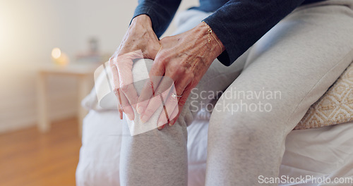 Image of Hands, pain and closeup of senior woman in bedroom with injury, hurt or accident at nursing home. Sick, illness and zoom of elderly female person in retirement holding leg with sprain muscle at house