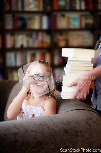 Image of Smile, stack of books and happy child in library, learning and study homework knowledge on couch. School, woman and excited girl with glasses in bookstore together with story, and education on sofa.