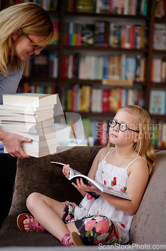 Image of Reading, books and woman with child in library with stack, learning and relax with study knowledge. Storytelling, happy mom and girl in bookstore together with story, fantasy and education on couch.