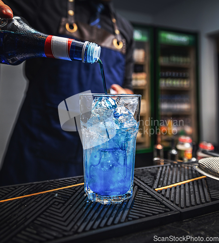 Image of Bartender pours blue liquor