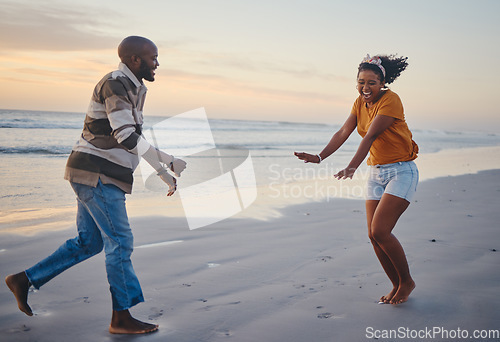 Image of Love, freedom and couple at a beach at sunset, laughing and having fun on summer vacation in nature. Relax, sea and black woman and man being playful and joking, enjoying sand and ocean walk together