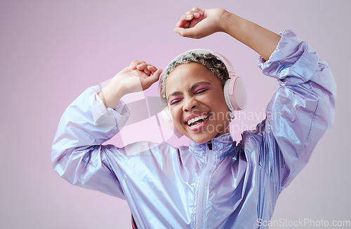 Image of Dance, fashion woman and headphone listening to music and dancing against purple studio background. African american female smile, audio streaming and enjoy sound with a playful and freedom attitude