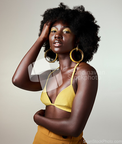 Image of Black woman, beauty and fashion, makeup or hair care and gold jewelry on gray studio background. Portrait, hand in afro hair and skincare cosmetics model from Jamaica posing for female empowerment.