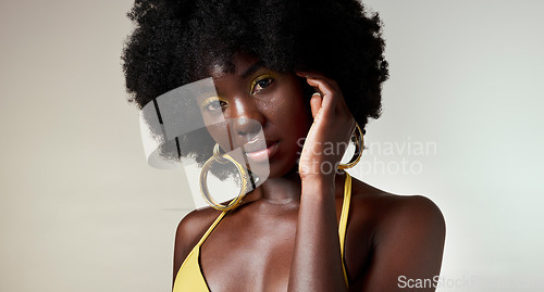 Image of Black woman, face and makeup with skincare beauty and cosmetics against grey backdrop. Model, hand and hair, show afro, skin wellness and health in portrait against studio background in Los Angeles