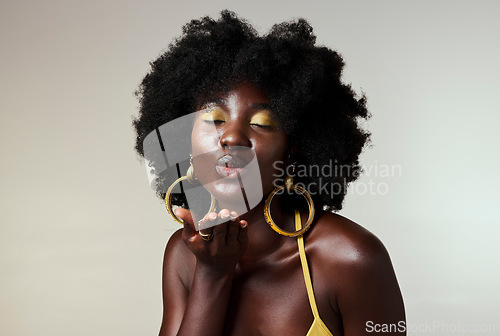 Image of Black woman, beauty and retro fashion, afro hair and blow air kiss with gold makeup and jewelry on studio background. Portrait, gesture and face of female cosmetics model from Jamaica flirting inside