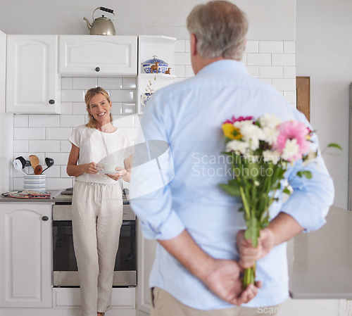 Image of Elderly, couple and flowers in kitchen for surprise, love and romance in their house. Woman, man and retirement together with bouquet to celebrate marriage, birthday or anniversary in their home