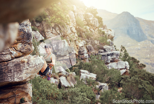 Image of Mountain, rock climbing and sport with a sports woman and climber abseiling outdoor in nature. Fitness, exercise and health with a strong female athlete training or in a workout in the mountains