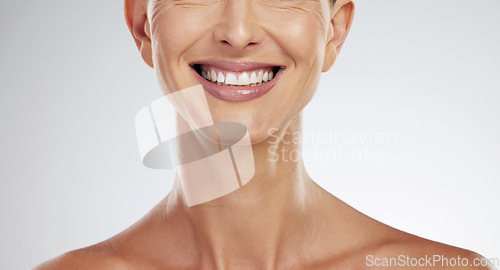 Image of Teeth, face and mature woman beauty showing her natural looking dental veneers posing on gray studio background. Oral health, healthcare and model woman happy with tooth hygiene dental care closeup.