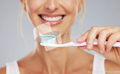 Image of Toothpaste, hand and toothbrush in morning smile with clean teeth, wellness and dental healthcare in mockup studio background. Zoom of mouth cleaning, cosmetic beauty and healthy self care routine