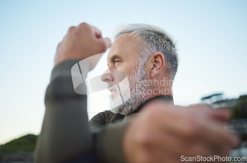 Image of Fitness, surf and stretching with a mature man getting ready to go surfing as a workout or training. Sports, exercise and health with a male surfer doing a warmup at the start of his cardio routine