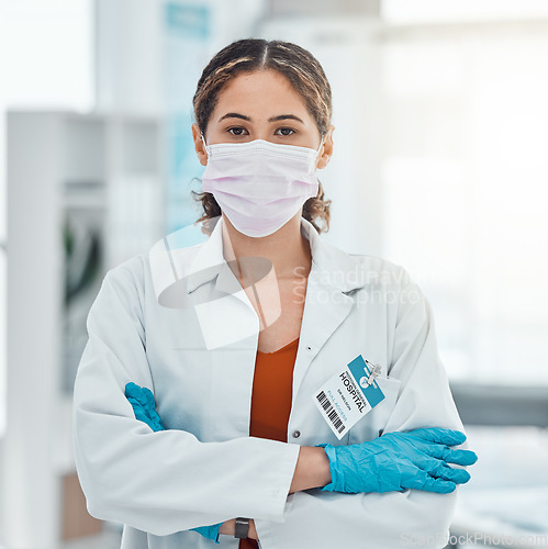 Image of Covid, medical and trust with doctor and arms crossed with a face mask in hospital for innovation, support or vision. Medicine, trust and leadership with portrait of healthcare employee in clinic