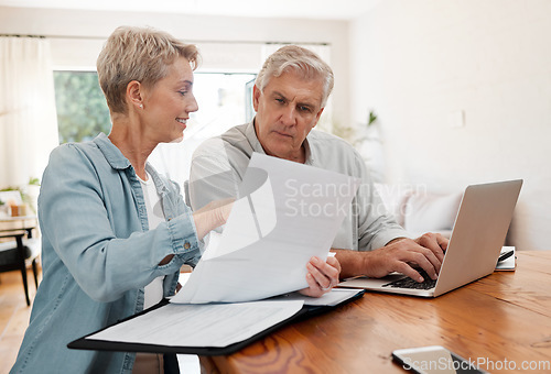 Image of Senior couple, laptop and home finance while reading paperwork documents and typing on computer for retirement savings, mortgage and online banking. Mature man and woman doing bill payment or booking