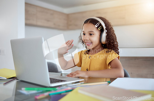 Image of Education, laptop and girl learning a virtual class from her kindergarten teacher via an educational online website. Video call, homeschooling and happy student in headphones waving at tutor teaching