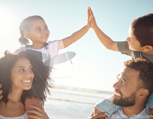 Image of High five, kids and parents at the beach on vacation, holiday and enjoying the sunny day. Family, father and mother on a day outside by ocean with the children on the backs, playing and smile.