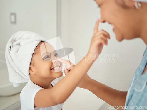 Image of A happy Mom, smiling child using cream and teaching skincare beauty routine to girl in a bathroom. Mother helping her daughter to learn to help her skin, hair and body healthy with self care products