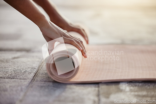 Image of Macro of yoga, floor and woman hands with mat after exercise in gym, home or patio. Girl roll up gear after training, workout and fitness in stretching, breathe and mindfulness practice outside
