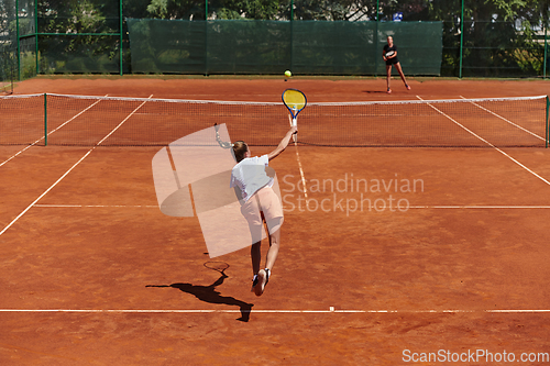 Image of Young girls in a lively tennis match on a sunny day, demonstrating their skills and enthusiasm on a modern tennis court.