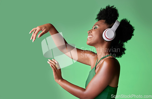 Image of Dance, studio and black woman dancing to music in headphones while streaming happy audio sounds from a playlist. Freedom, smile and young African girl enjoying listening to radio with mockup space
