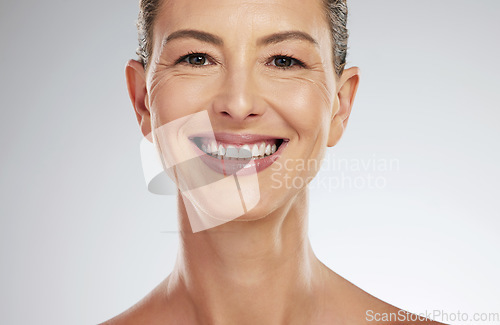Image of Face, portrait and skincare for mature woman with smile for facial health against a grey mockup studio background. Elderly model happy about natural wellness and dermatology with mock up space