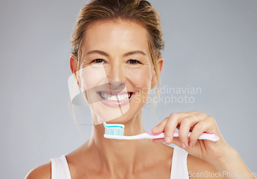 Image of Senior woman and portrait with toothbrush for dental treatment and teeth whitening at grey studio. Mature, healthy and happy lady with toothpaste for mouth cleaning and white smile face mockup.