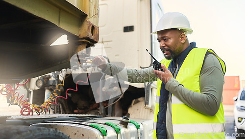 Image of Man, smile and work in logistics with radio in hand for communication while load container on truck at port. Black man, talking and helmet working in shipping, cargo and transportation in Cape Town