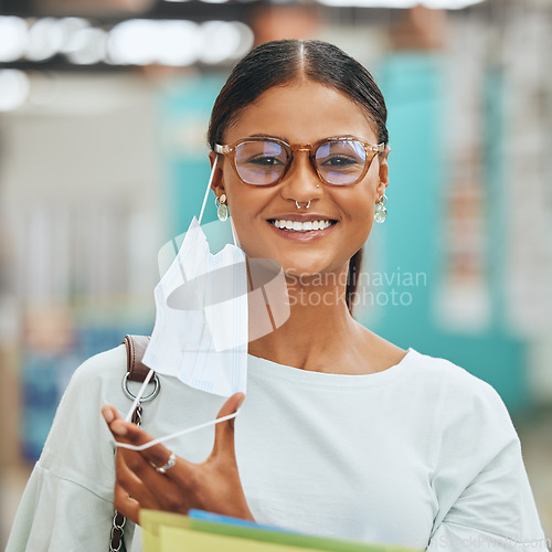 Image of Covid, university and student with smile and face mask at the end of pandemic in classroom at school. Portrait of a happy and young girl removing a mask after covid 19 virus while studying at college