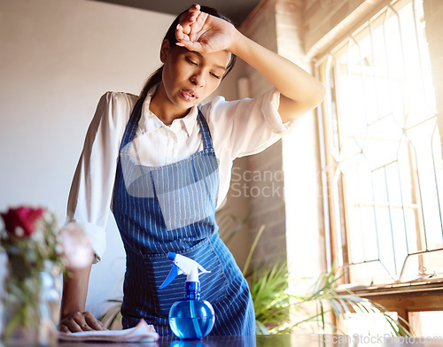 Image of Cleaning house, burnout and tired cleaner working hard on dirty table and furniture feeling exhausted. Unhappy, frustrated and sweaty woman overworked in a difficult stressful job with daily pressure