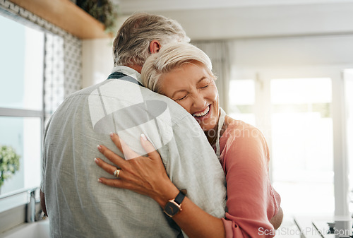 Image of Hug, love and safe with a senior couple hugging or embracing in the kitchen of their home together. Happy, smile and affection with an elderly male and female pensioner sharing a warm embrace