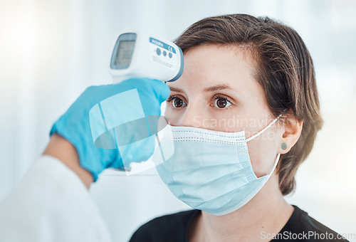 Image of Covid, thermometer and doctor scan fever temperature of woman with mask consulting in hospital. Female patient test for healthcare, safety and protection against coronavirus, illness and virus.