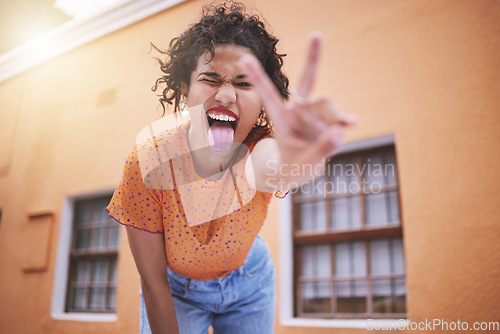 Image of Closeup beautiful mixed race fashion woman pouting and gesturing peace against an orange wall background in the city. Young happy hispanic woman looking stylish and trendy. Carefree and fashionable